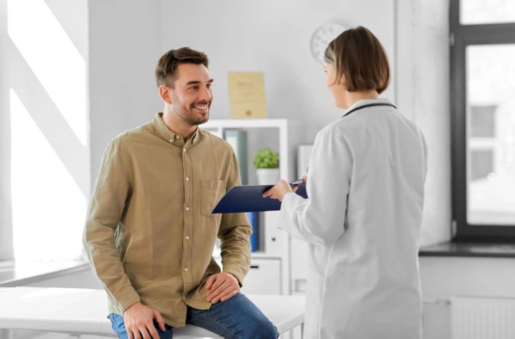 A doctor performing pre-employment medical check on a young man.