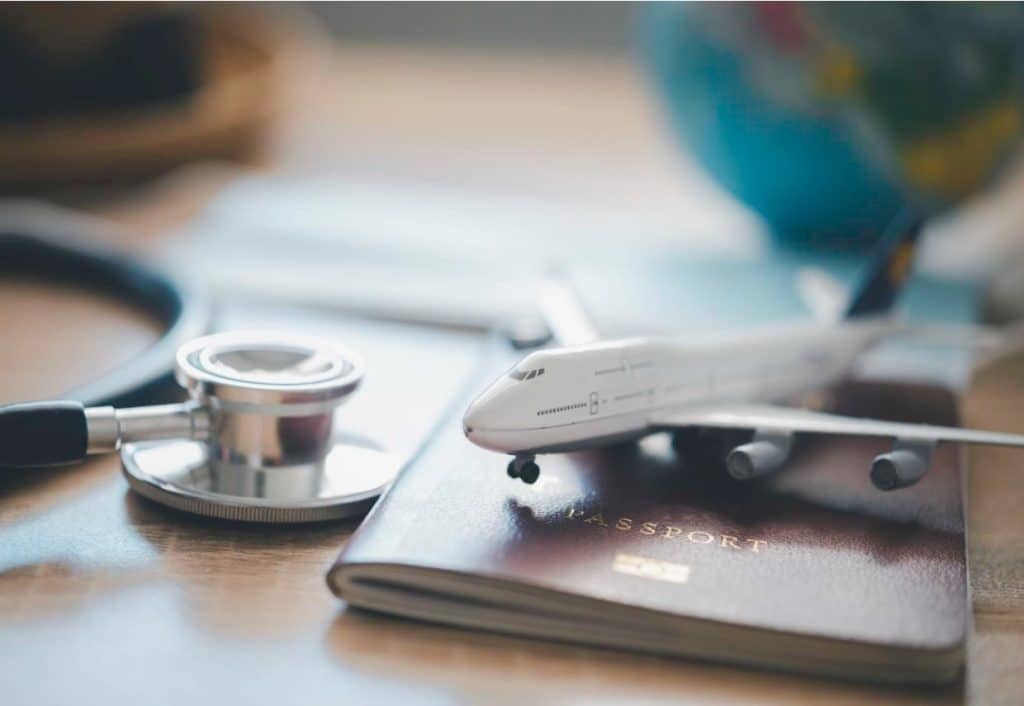 Stethoscope, plane and passport - medical travel advice concept