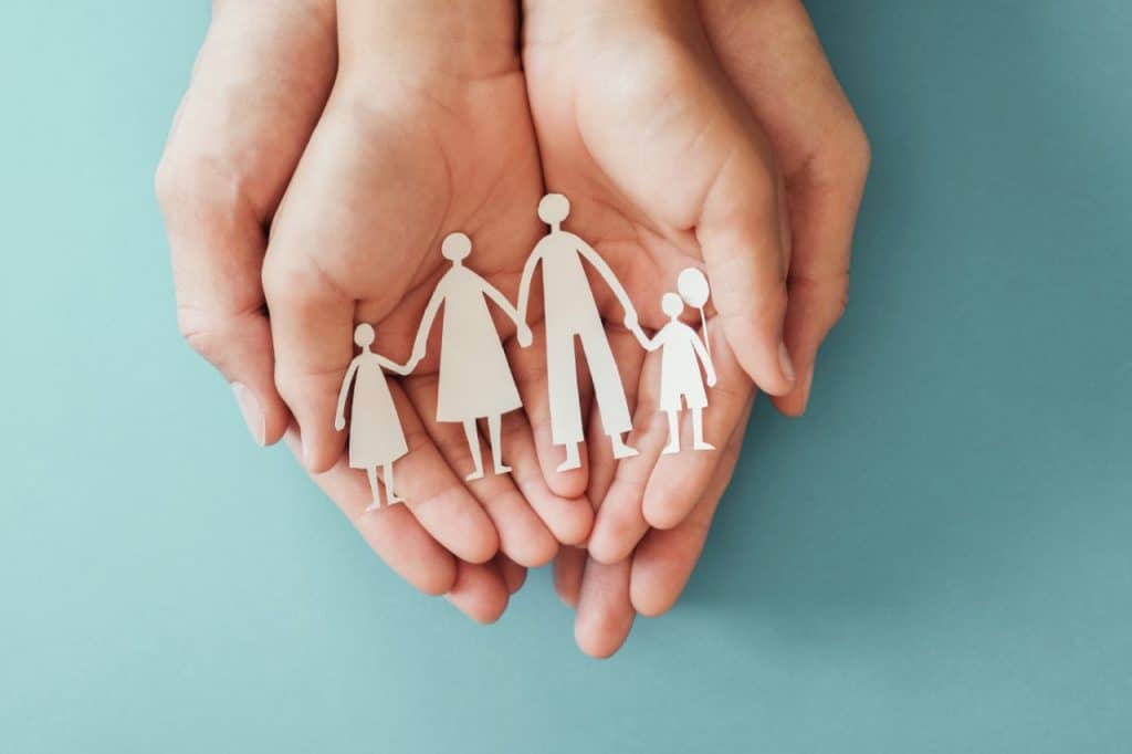 Picture of hand holding a cut out craft of a family