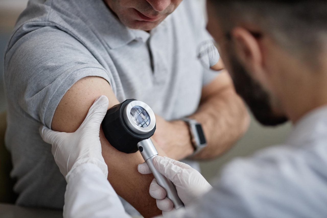 Middle aged outdoor worker undergo skin cancer check by a doctor.